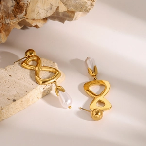 Détail de boucles d'oreilles symbole infini avec perles poires blanches sur pierre