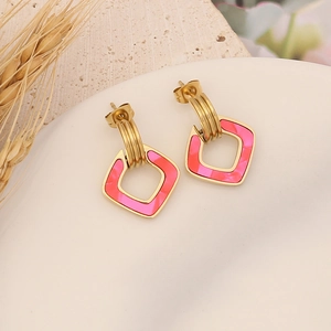 Golden geometric stainless steel earrings with pink marble inlay on a stone tray