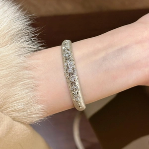 French retro hollow patterned zircon open bangle worn by a model in a luxury setting