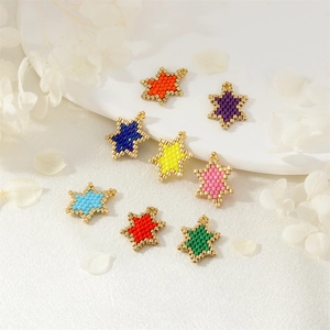 Handmade woven star pendants with colorful seed beads and gold trim on white silk