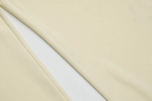 Vue macro du pantalon à cordon français montrant la texture du tissu crème de qualité