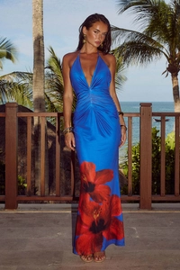 Floral print halter backless maxi dress for women on a tropical beach background