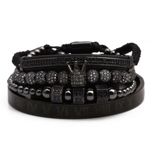 Close-up of men black crown bead bracelet set with woven rope and Roman numeral bangle