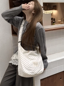 Detailed view of the black polka dot canvas bag fabric texture and branding woven label
