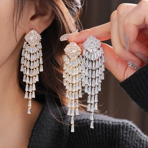 Detail showing gold and silver geometric tassel earrings with sparkling zircon stones