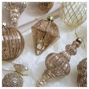 Detail of champagne gold Christmas ornaments with glitter coating and relief patterns