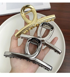 Detail of gold and silver large metal hair claw clips with polished mirror finish