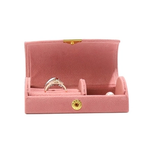 Pink velvet travel jewelry box with gold snap button and internal ring compartments