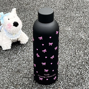Détail de la gourde en acier noir mat avec des nœuds roses et des motifs de cœurs