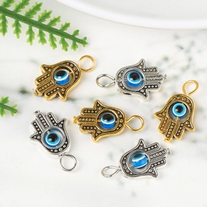 Golden and silver Hamsa Hand pendants with evil eye beads for DIY jewelry making