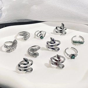 Gothic silver snake rings set with green zircon stones in a minimalist aesthetic style