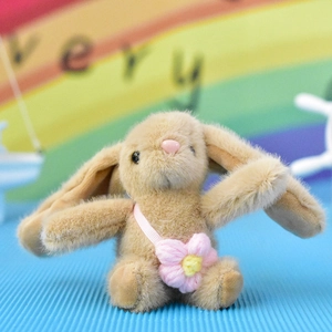 Detailed close-up of a cute tan plush rabbit charm with a pink knitted flower accessory
