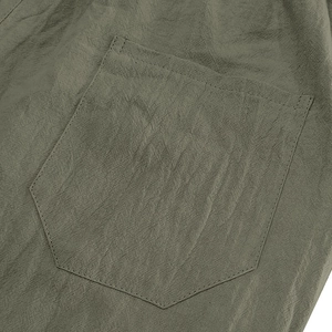Detail of army green linen fabric showing pocket stitching and natural texture