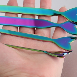 Macro view of rainbow stainless steel mermaid tail cutlery showing size and metallic finish