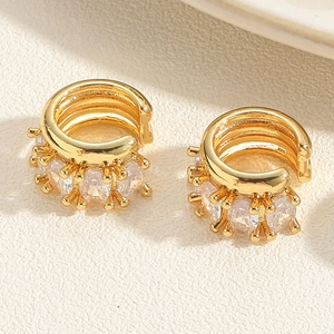 Detailed macro view of triple-layered gold ear cuff with sparkling zircon stone setting