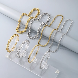 Collane e bracciali in acciaio inossidabile oro e argento su espositori grigi