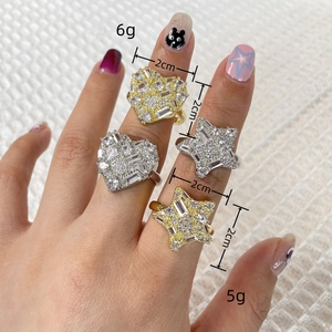 Detailed view of 2cm heart and star gold rings with micro-set zircons on hand