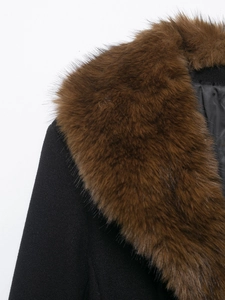 Detailed macro view of high-quality faux fur collar on a black wool coat for women