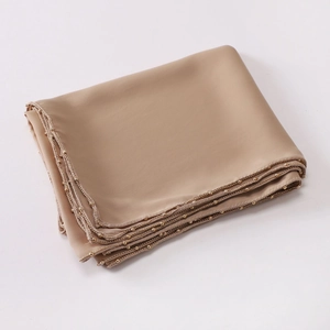 Detail of champagne satin scarf with elegant golden bead trim on the edges