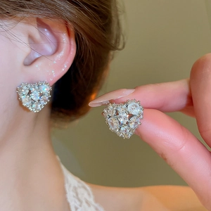 Close-up of 18k gold plated heart earrings with sparkling cubic zirconia on ear