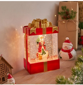 Detail of red Christmas lantern with Santa and glitter snow scene inside