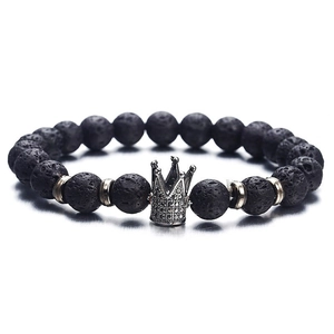 Lava stone bead bracelet with a silver crown charm and metal accents on white backdrop