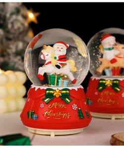 Detail of Santa on unicorn crystal ball with red base and Merry Christmas gold lettering