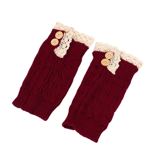 Close-up of deep red cable knit leg warmers with beige lace trim and wooden buttons