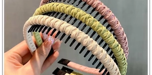 Close-up of woven non-slip headbands with teeth in beige, light green, and pink colors