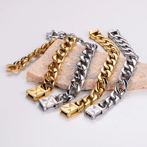 Luxury Cuban chain bracelet in gold and silver finish on a stone platform