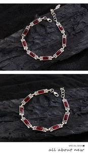 Detail of S925 silver bracelet with red rectangular crystals on a black charcoal base