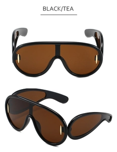Detail view of oversized one-piece sunglasses with black frames and tea lenses