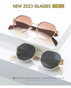 Détail de lunettes de soleil polygonales en métal doré avec verres dégradés marron et gris
