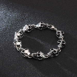 Close-up of gothic silver skull links on a men's heavy stainless steel bracelet