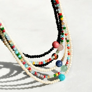 Close-up of layered bohemian beaded necklace featuring agate, crystal, and amazonite beads