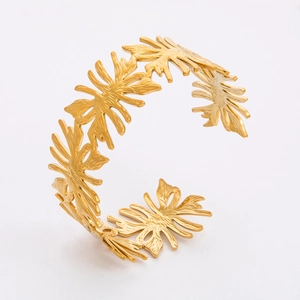 Detail view of 18k gold plated stainless steel cuff bracelet with leaf cutout pattern