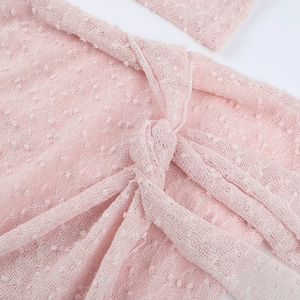 Détail de la dentelle en maille rose avec texture à pois sur robe courte moulante
