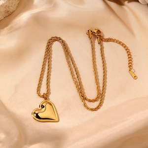 Detail of gold heart pendant on a twisted chain with lobster clasp and extension
