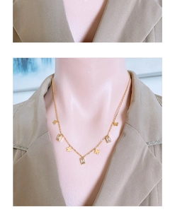Detail of gold butterfly necklace with rectangular clear zircons on a mannequin