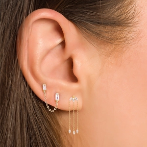 Detailed view of gold chain earrings with marquise cubic zirconia and tassel fringe