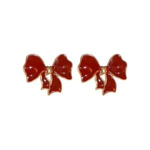 Elegant vintage red enamel bow earrings with gold metal borders on a white background