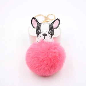 Detail of a bright pink plush ball keychain with a cartoon French bulldog leather head