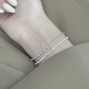Detail of 925 sterling silver layered bracelet with textured and smooth bead chains