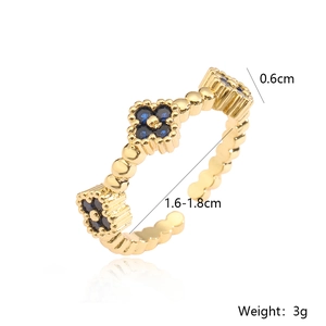 Detail view of flower ring with blue zircon inlay and beaded texture gold finish