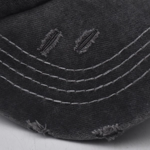 Detail shot of the vintage washed black cotton baseball cap with distressed brim and stitching