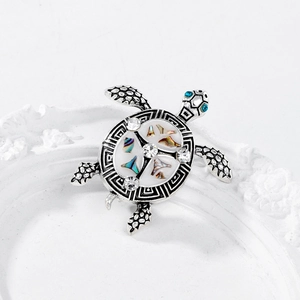 Vintage silver sea turtle brooch with iridescent shell inlay and sparkling blue crystal eyes