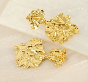 Macro view of irregular lava texture and 18K gold plated molten leaf earrings finish