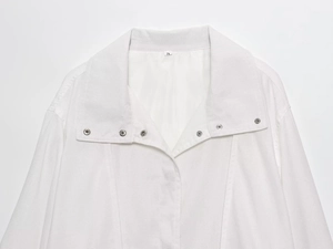 Close-up of white pilot jacket collar with silver metal snaps and size S label