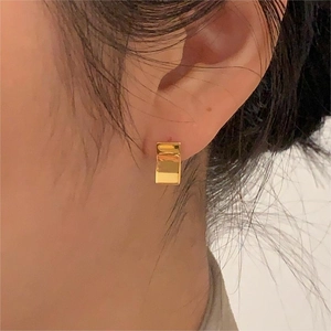 Minimalist geometric gold earrings for women, rectangle stud design on model's ear lobe