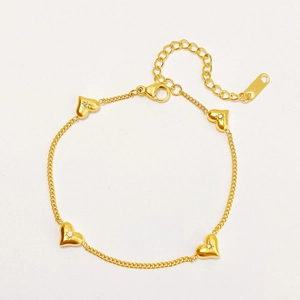 Detailed view of gold heart bracelet featuring sparkling starburst rhinestones and lobster clasp